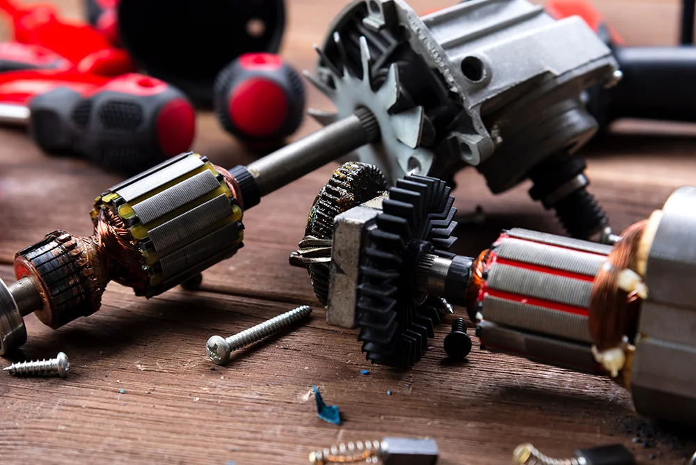 Details of electrical appliance and repair tools on a wooden table in a repair shop